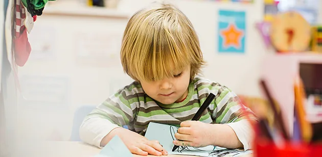 A boy concentrating on a drawing