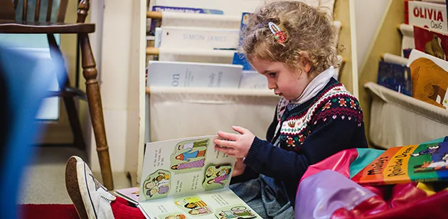 A girl reading a picture book